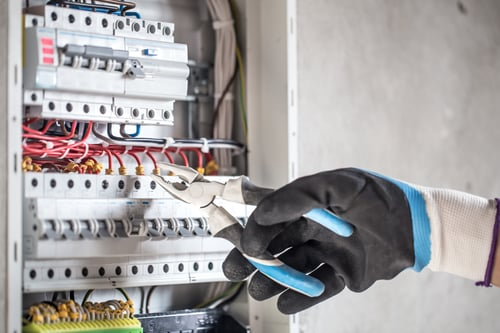 Electrician working inside a residential breaker panel